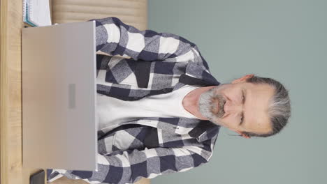 Vertical-video-of-Old-man-chatting-on-laptop.
